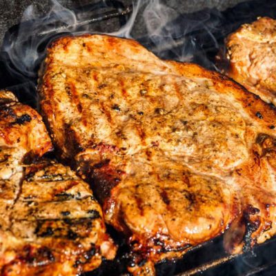 Pork chops cooking on grill