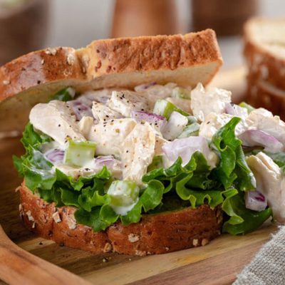Closeup of chicken salad sandwich with lettuce on whole grain bread