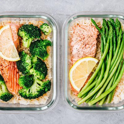 Salmon on rice with asparagus and broccoli in lunch box containers