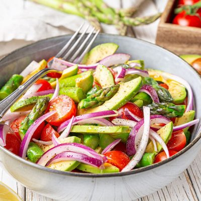 Vegan summer salad in grey bowl on rustic wood counter