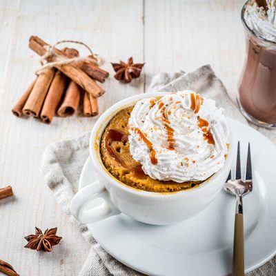 Pumpkin mug cake topped with whipped cream and caramel