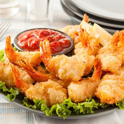 Coconut shrimps on bed of lettuce on plate